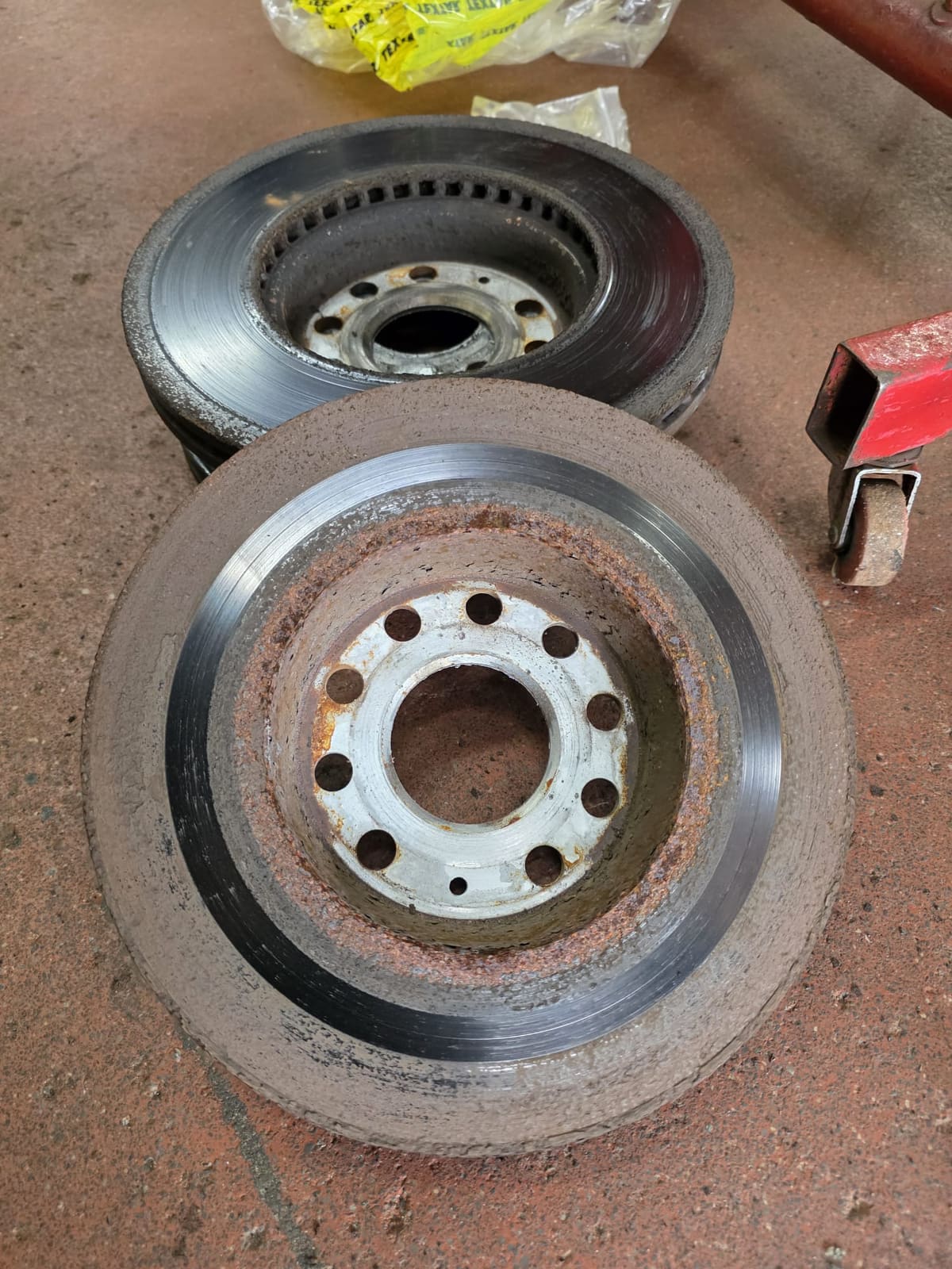 Two removed brake rotors with rust across the hubs and outer edges of the braking surface