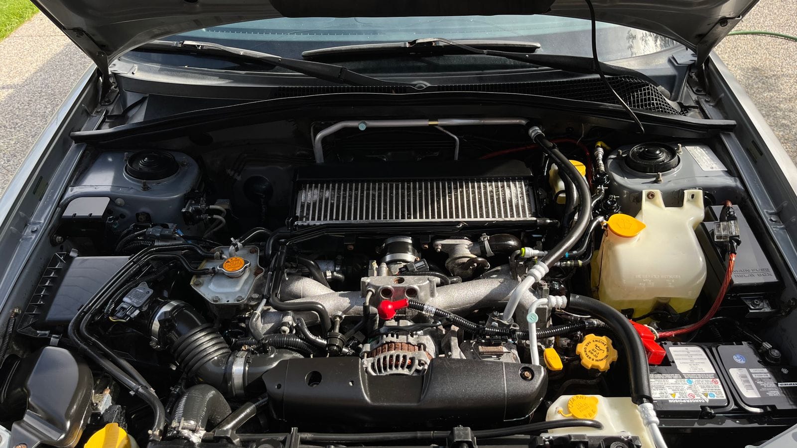 The coolant reservoir and cap in a car engine bay