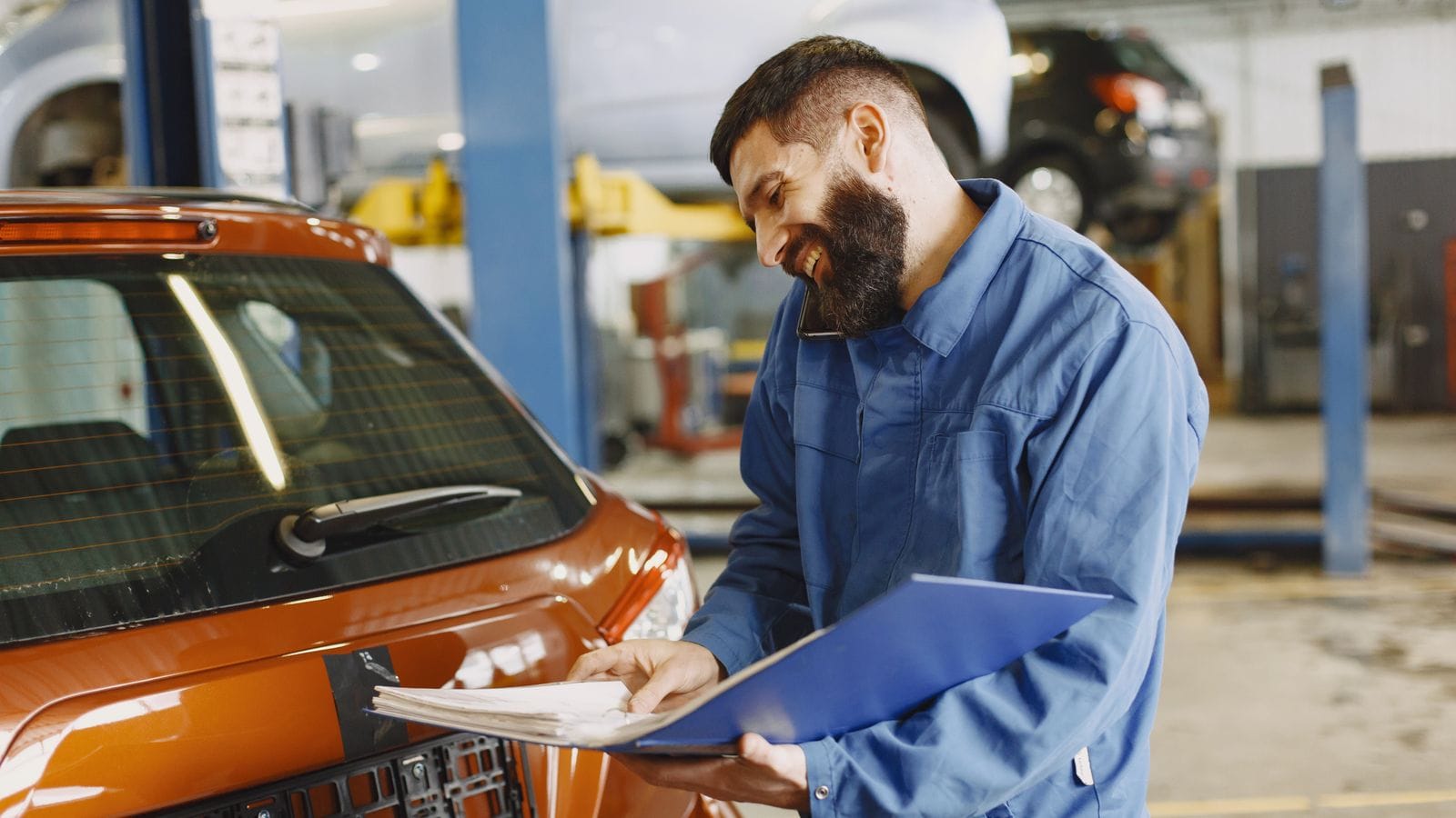 A technician inspecting a used car in the shop